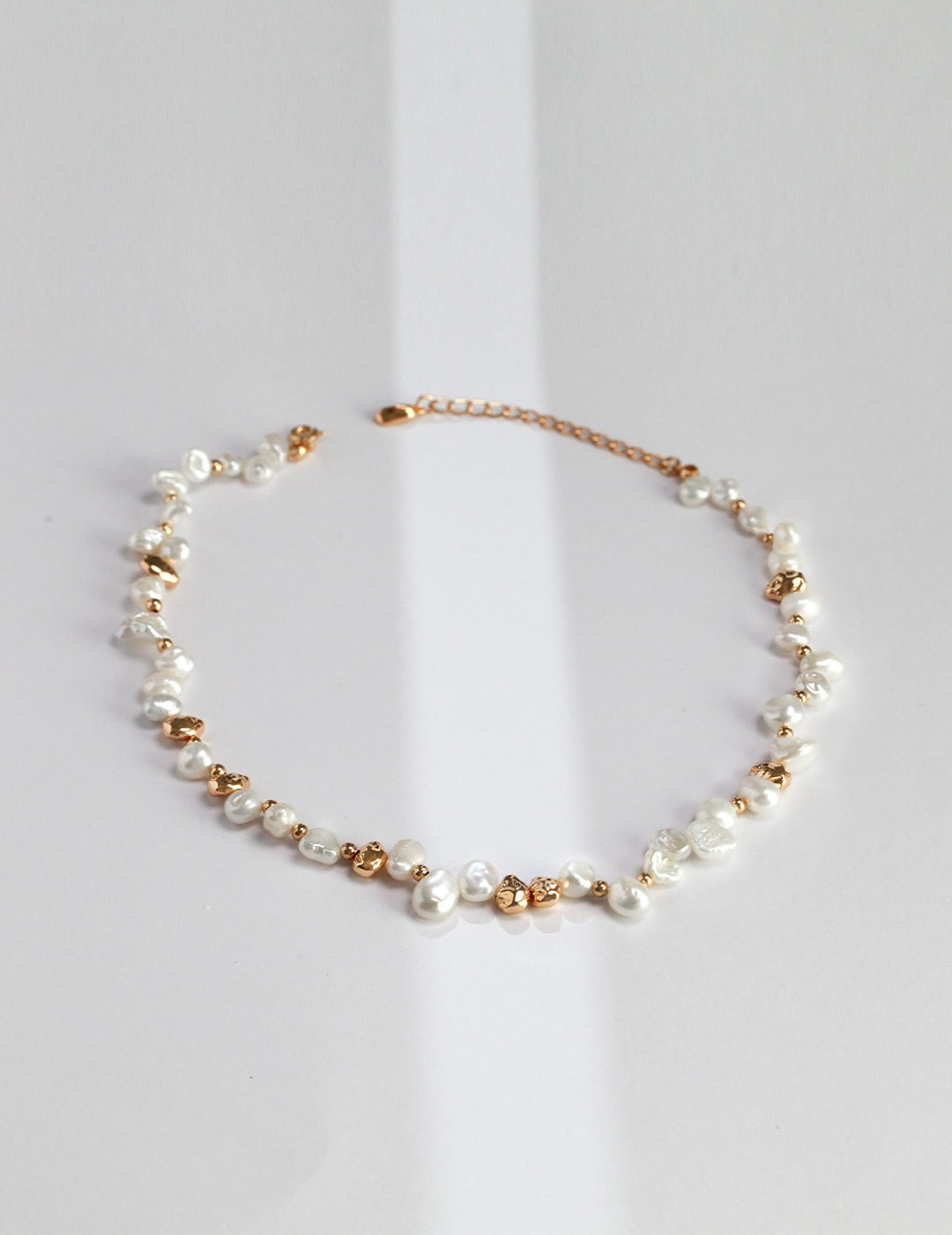 A high-resolution studio shot of the Elysian necklace on a clean background. This main image displays the striking contrast between the creamy, iridescent baroque pearls and the hand-finished silver nuggets, emphasizing the brand's commitment to handcrafted, artisan luxury jewelry.